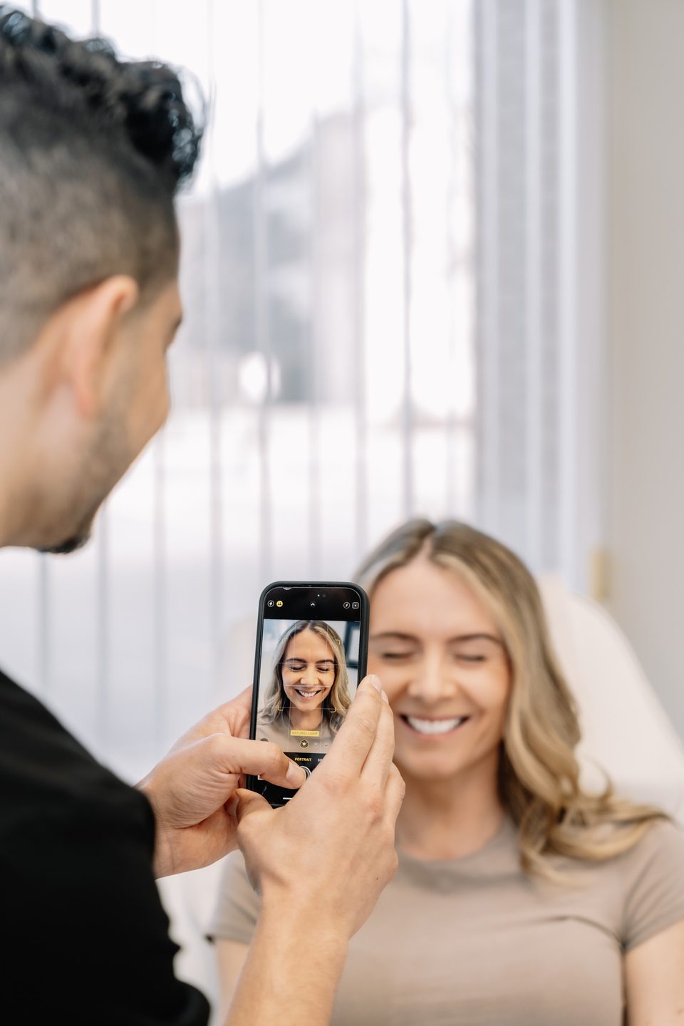 Dr. Justin Khetani taking standardised clinical photographs of a patient with a phone during a surgical consultation