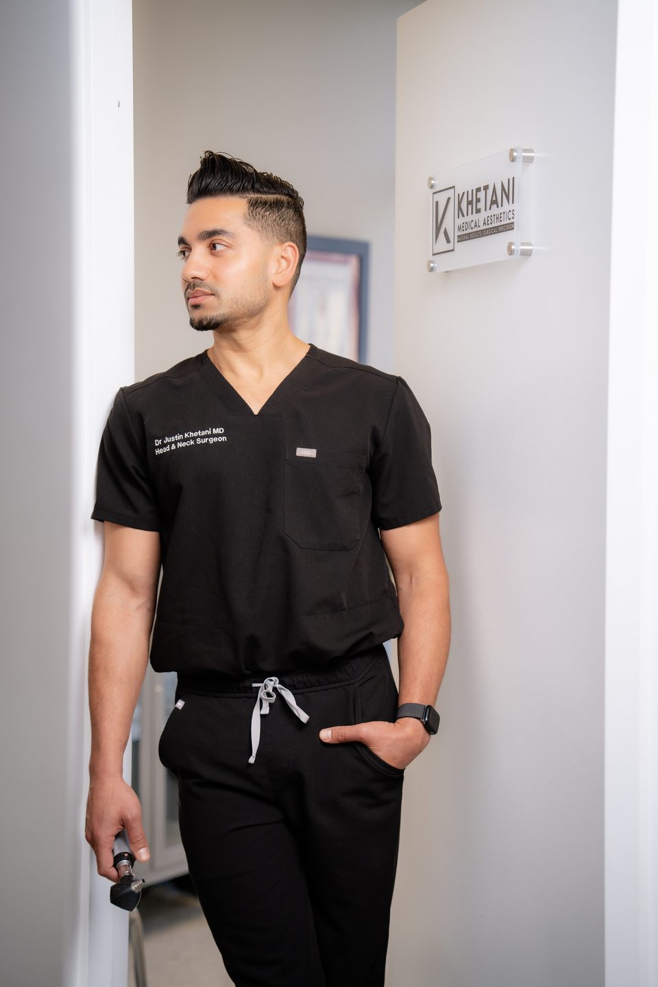 Dr. Justin Khetani at the doorway of the Burlington clinic beside the practice sign
