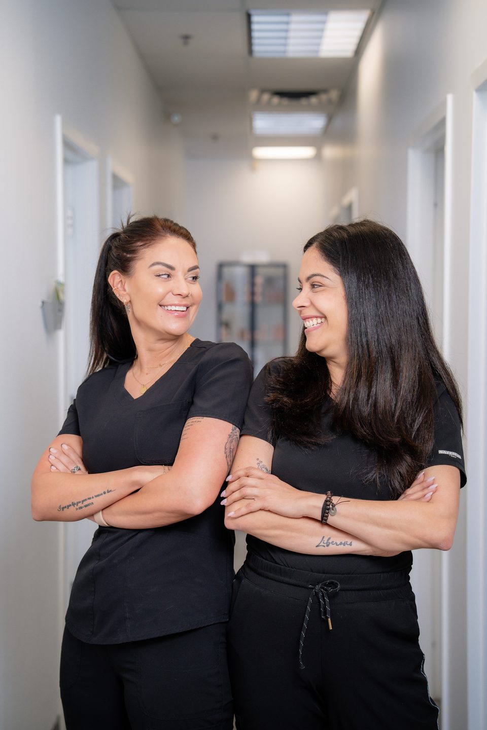 Brandi and Ana, the two members of the clinic team, standing together in a hallway of the Burlington clinic