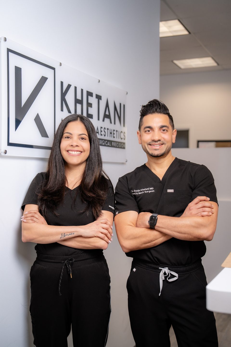 Dr. Justin Khetani with a member of the clinic team beside the practice sign in the Burlington office
