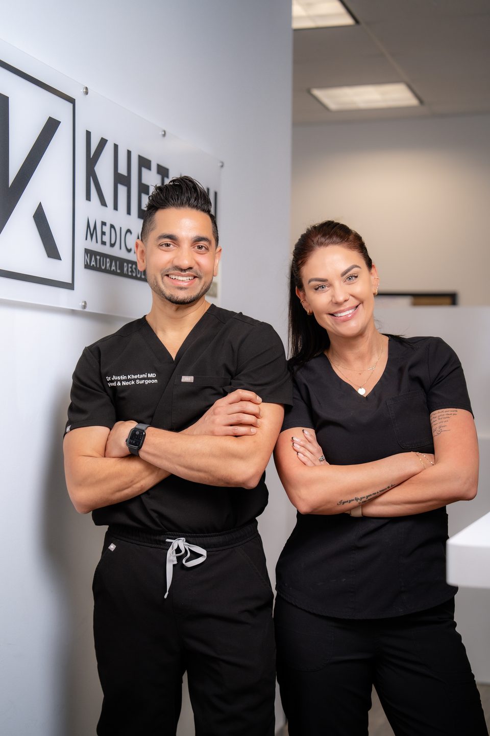 Dr. Justin Khetani with a member of the clinic team beneath the practice sign in the Burlington office